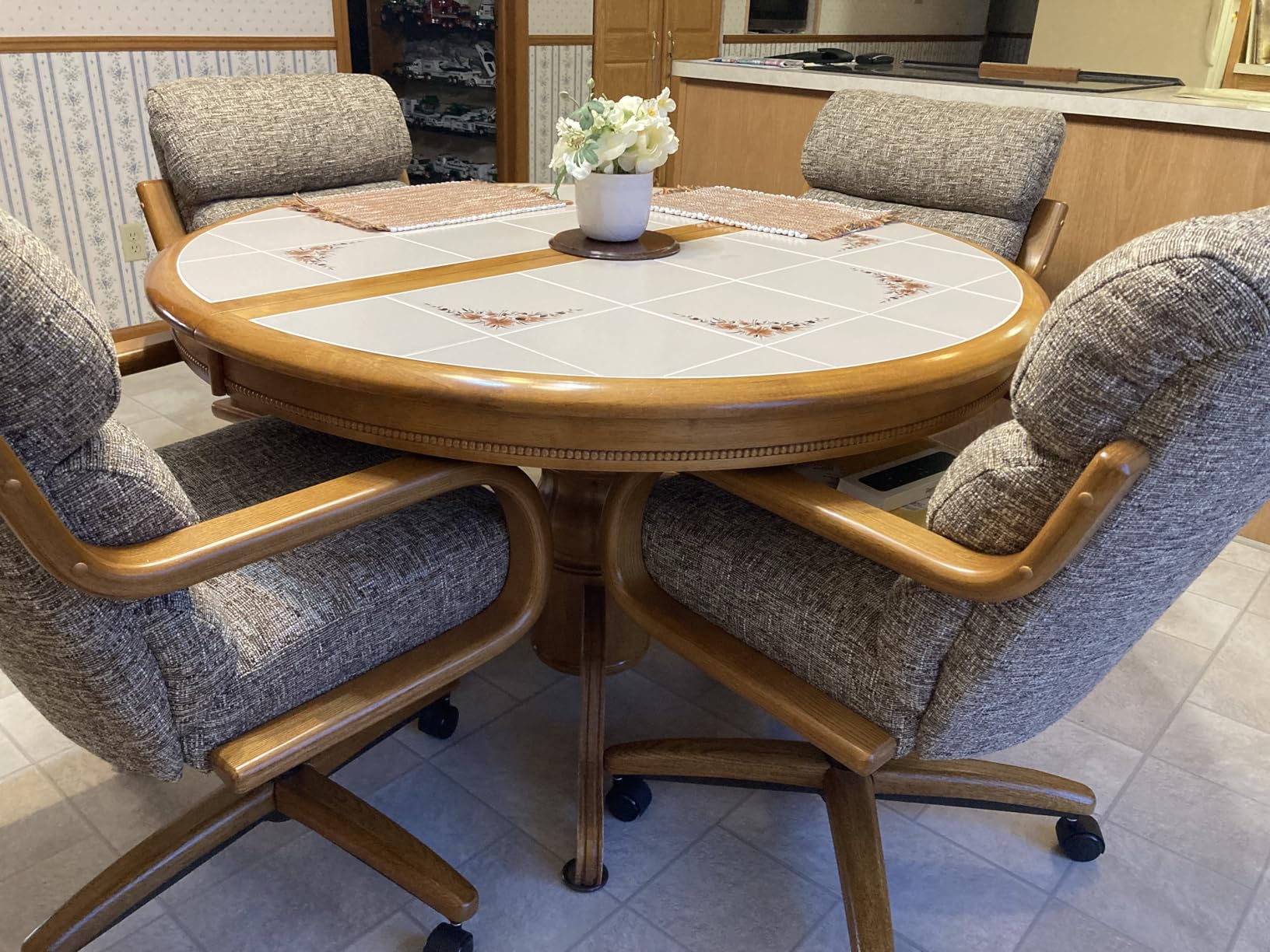 Tile-top dining table with gray upholstered Chromcraft chairs in a customer kitchen